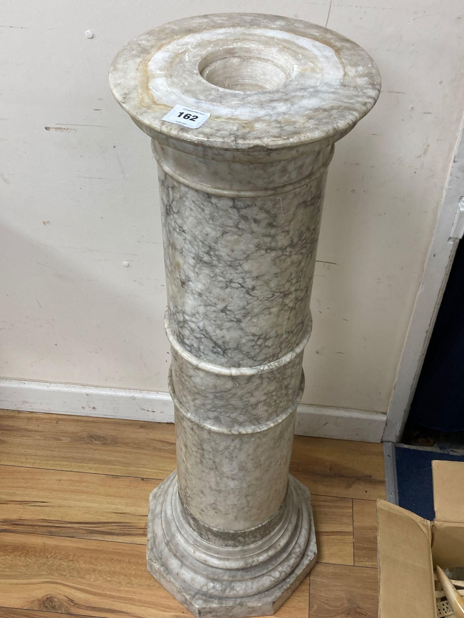 A variegated cream marble pedestal, height 110cm